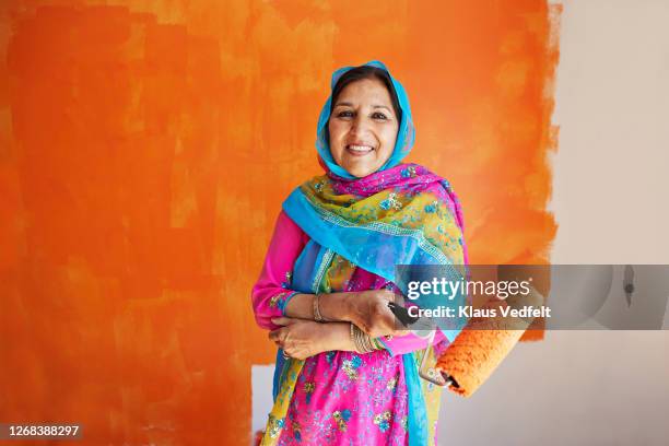 woman against painted wall during home renovation - woman diy stock pictures, royalty-free photos & images