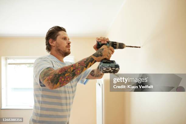 man using drill on wall at home - drill stock pictures, royalty-free photos & images
