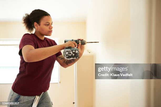 woman using drill on wall at home - drill stock pictures, royalty-free photos & images