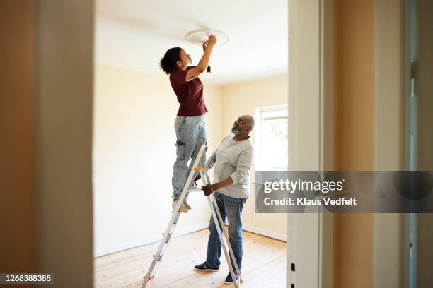 woman renovating home with father - bijstellen stockfoto's en -beelden