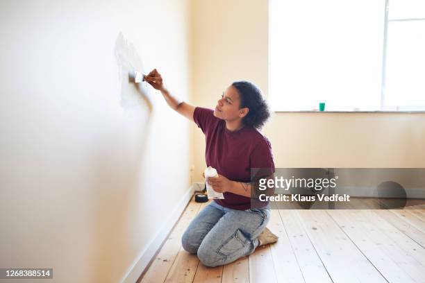 woman finishing wall while renovating home - interior finishing stock pictures, royalty-free photos & images