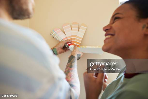 couple comparing color swatch with wall - farbprobe stock-fotos und bilder