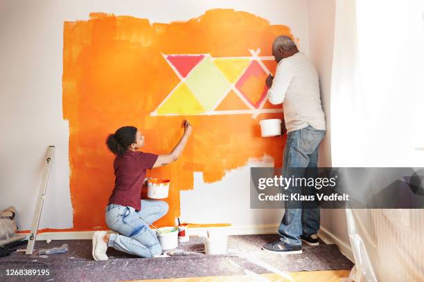 father and daughter painting wall at home - full body paint stock pictures, royalty-free photos & images