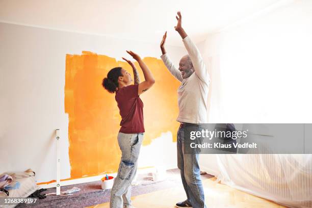 family having fun during home renovation - black man high 5 stock pictures, royalty-free photos & images