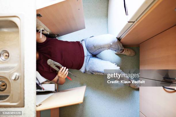 woman repairing kitchen sink at home - plier stock pictures, royalty-free photos & images