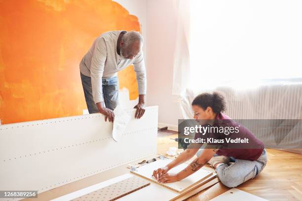 family installing furniture at home - furniture assembly stock pictures, royalty-free photos & images