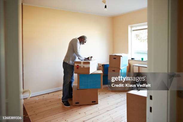 elderly man packing boxes at home - senior moving house stock pictures, royalty-free photos & images