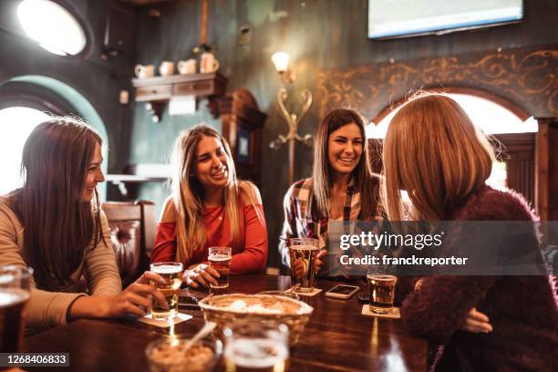 people talking indoors in a pub with the beers - italy beer stock pictures, royalty-free photos & images