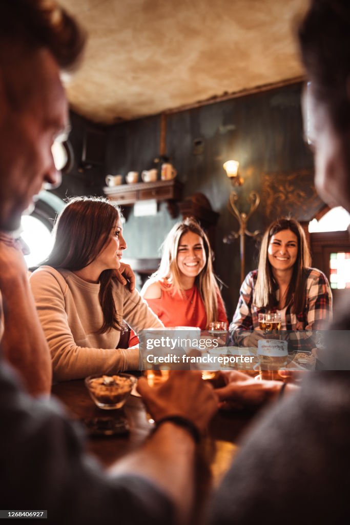 People talking indoors in a pub with the beers