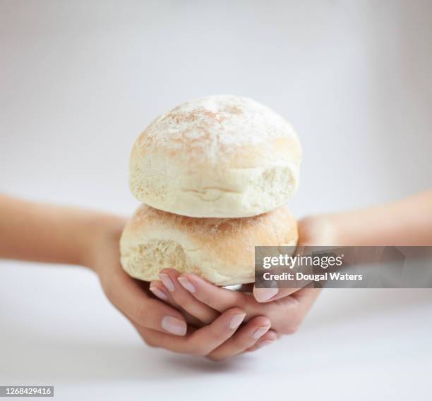 hands holding soft white bread rolls, close up. - bun bread stock pictures, royalty-free photos & images