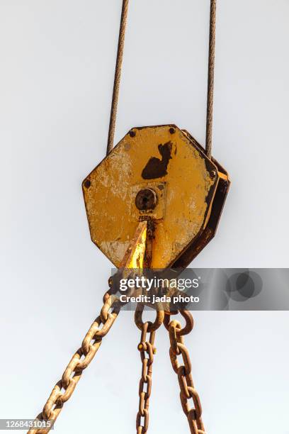 steel pulley with steel chain suspended from a steel cable - lier stockfoto's en -beelden