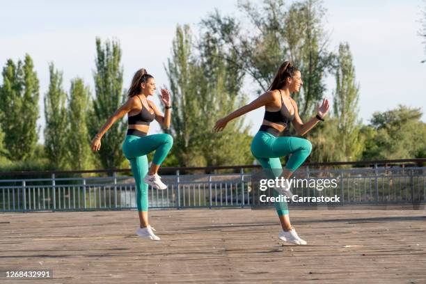 twin sisters perform sport at sunset in park. - girls fanny stock pictures, royalty-free photos & images