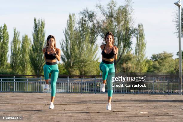 twin sisters perform sport at sunset in park. - girls fanny stock pictures, royalty-free photos & images