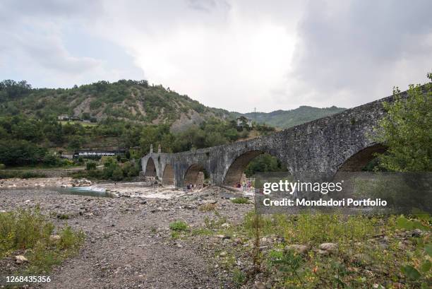 The Gobbo bridge or Ponte Vecchio at the entrance to the medieval Italian village of Bobbio. Piacenza , August 11th, 2020