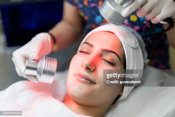 femme subissant le traitement facial de thérapie de luminothérapie infrarouge - soins de beauté photos et images de collection