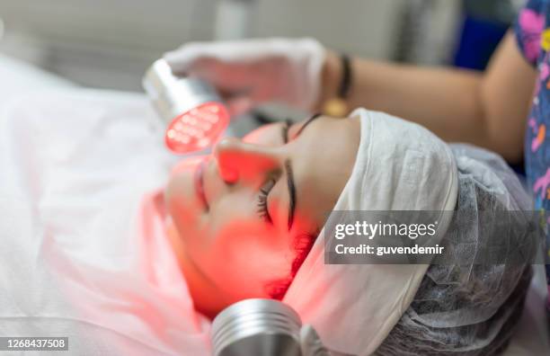 vrouw die infrarode lichttherapie gezichtsbehandeling ondergaat - medical laser stockfoto's en -beelden
