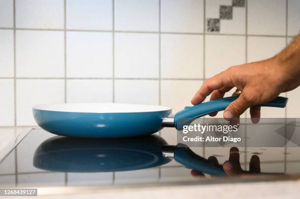 man cooking with a frying pan in the kitchen. - braadpan stockfoto's en -beelden