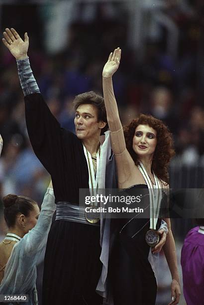 Sergei Ponomarenko and Marina Klimova , both of the Eastern Unified Nations wave to the crowd after winning the gold medal in the Ice Dancing event...