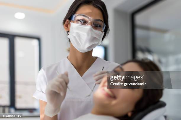 zahnärztin und patientin in der zahnklinik - dental hygienist stock-fotos und bilder