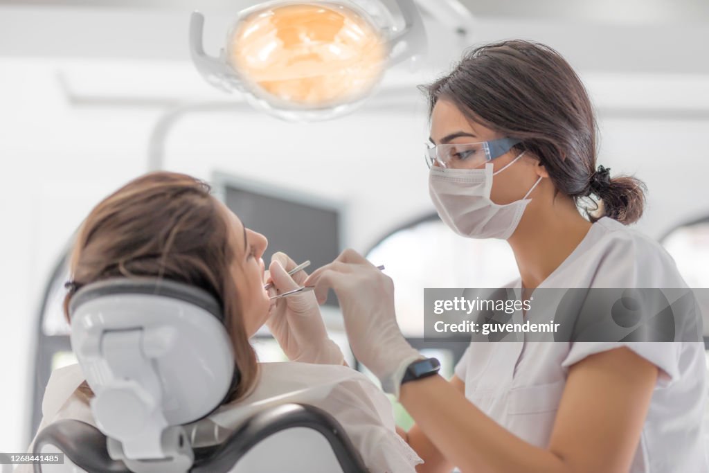 Female Dentist examining her patient in dental clinic