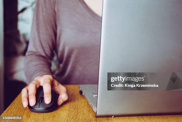 a woman using a laptop - computer mouse stock-fotos und bilder