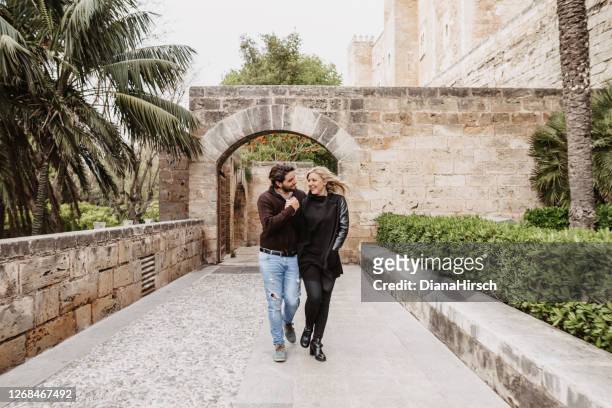 young couple walking old town of palma de mallorca - old town stock pictures, royalty-free photos & images