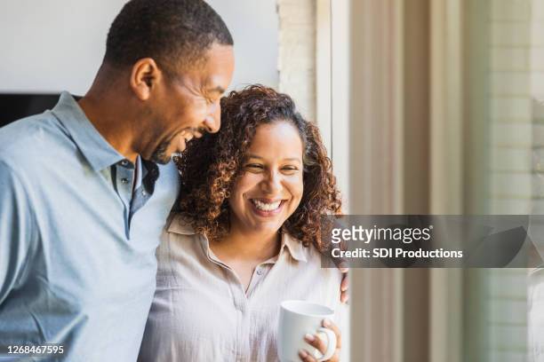 mid adult couple enjoys time together at home - mid adult stock pictures, royalty-free photos & images