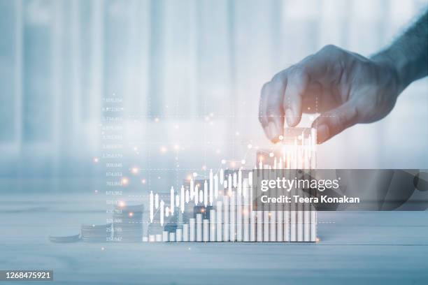 hand of a businesswoman is arranging wooden toys as steps along the rising graph.concept for business growth success process - performance improvement stock pictures, royalty-free photos & images