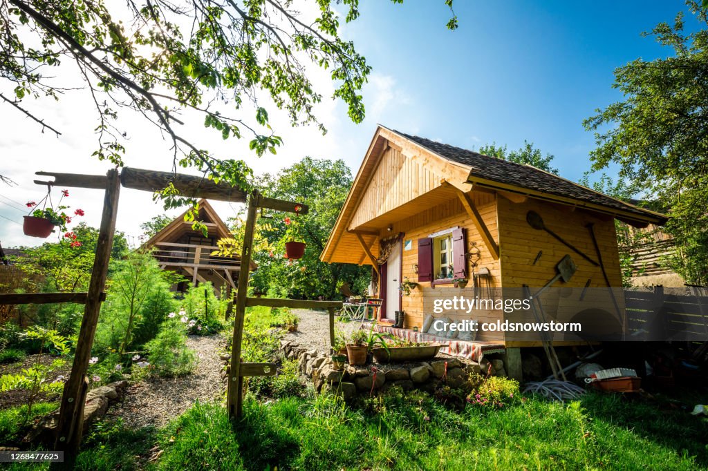 Schöner Blumengarten und Holzhüttenhaus