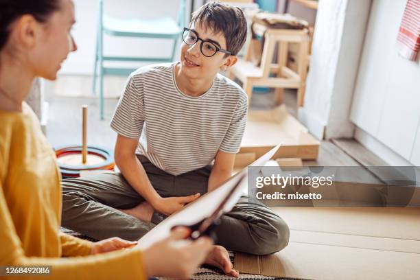 brother and sister cutting cardboard making a dog house - boy and girl talking stock pictures, royalty-free photos & images