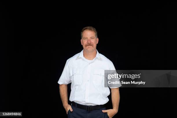 fire chief portrait in non-emergency uniform on a black background - häuptling stock-fotos und bilder