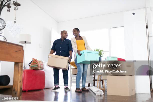 african female couple carry boxes into their new home - equal opportunity stock pictures, royalty-free photos & images