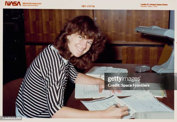 American NASA Astronaut Sally Ride smiling as she turns to face the camera while going over post-flight data from STS-3 during a crew debriefing...