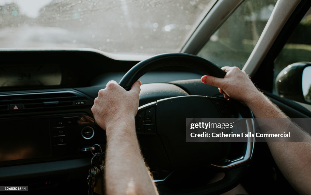 Man grips steering wheel with two hands