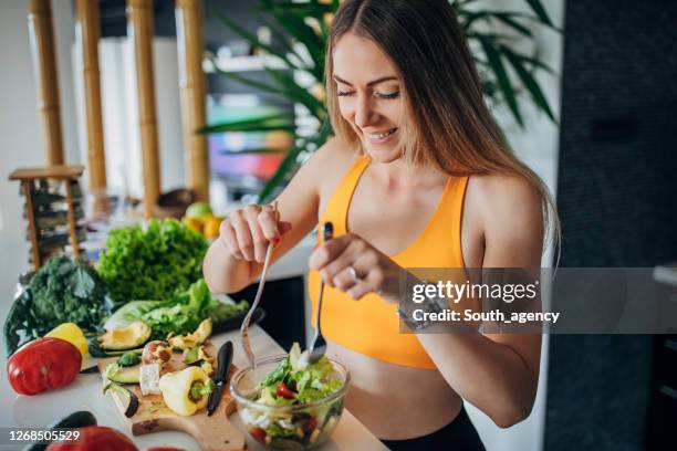 geschikte vrouw die gezonde plantaardige salade voor ontbijt maakt - sportsperson stockfoto's en -beelden