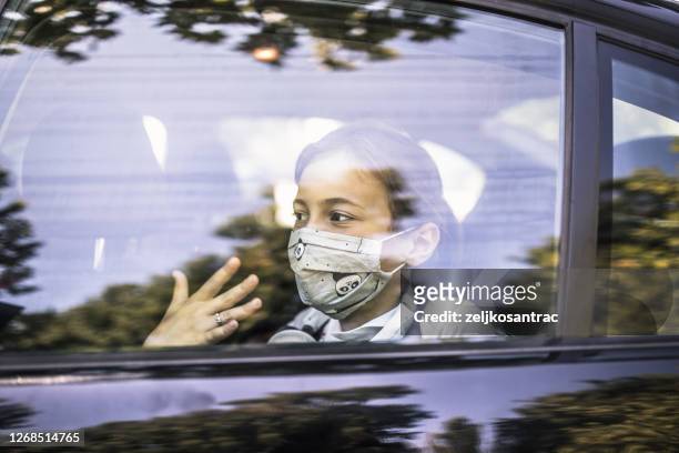 girl with protective mask peeking through the car window - kid peeking stock pictures, royalty-free photos & images