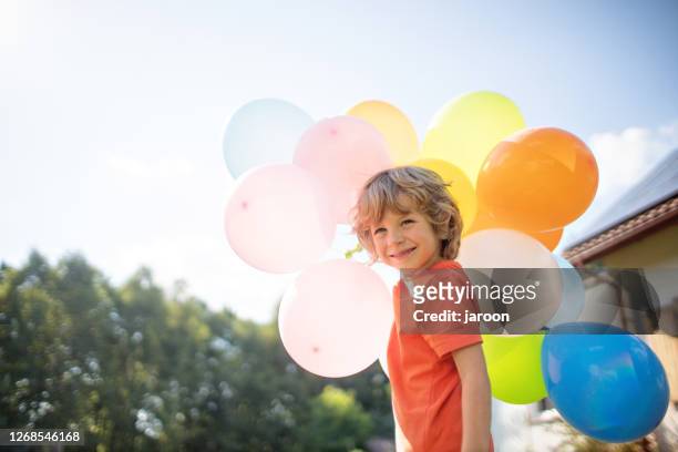 4 jahre alten jungen mit bunten luftballons draußen - 4 5 years stock-fotos und bilder