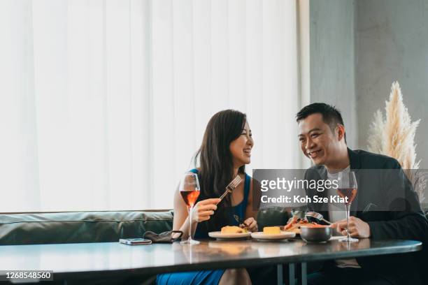 gift asiatiska par äta och njuta av sina samtal - asian restaurant bildbanksfoton och bilder