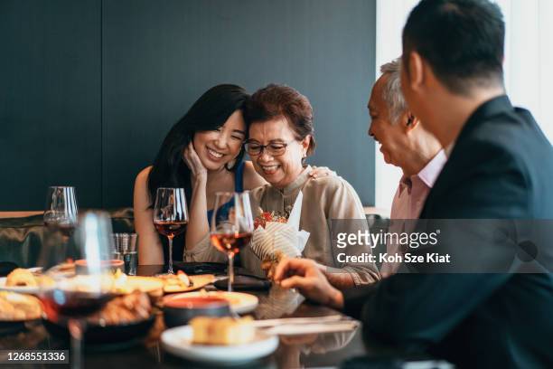 asian family dining and celebrating mother's day or birthday - dining stock pictures, royalty-free photos & images