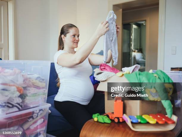 woman sorting used baby clothes to avoid wasting. - possession stock pictures, royalty-free photos & images