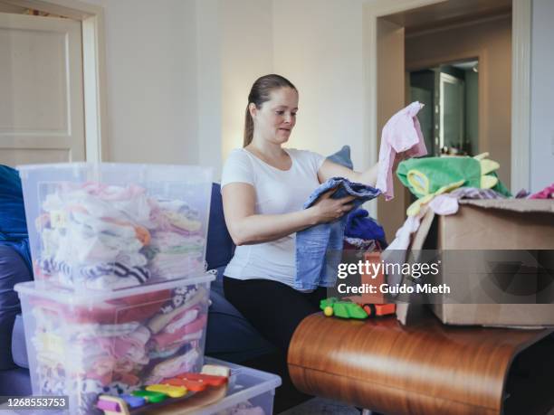 woman sorting used baby clothes to avoid wasting. - possession stock pictures, royalty-free photos & images