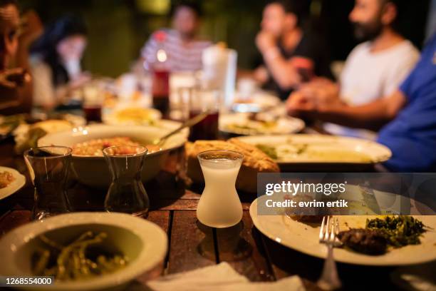 glass of raki and appetizers on the table for dinner - ouzo stock pictures, royalty-free photos & images