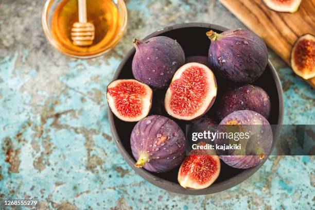 fresh figs and honey on rustic background - purple figs stock pictures, royalty-free photos & images