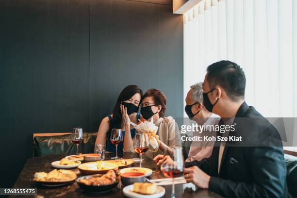 la famiglia asiatica pianifica una sorpresa per la festa della mamma o il compleanno durante l'epidemia di covid - chinese mothers day foto e immagini stock