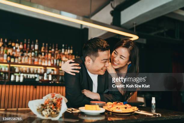 mooi aziatisch paar dat de dag van de valentijnskaart of verjaardag in een restaurant viert - asian couple dining stockfoto's en -beelden