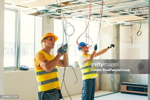 electricistas cableado de una nueva construcción - flat inspection fotografías e imágenes de stock