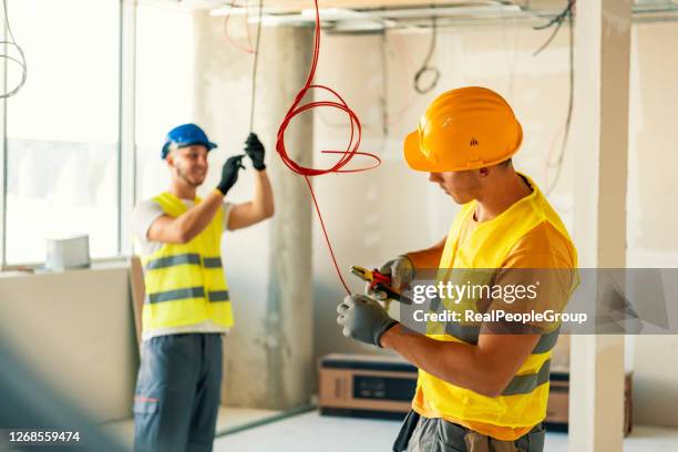 elektricien en collegan die bedrading controleren - draadtang stockfoto's en -beelden