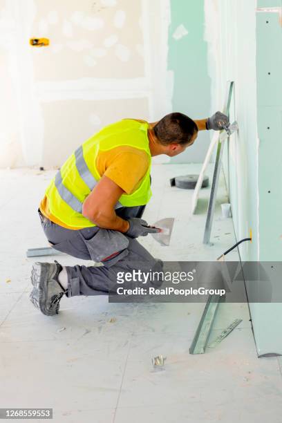 plasterer putting plaster on wall. slow motion - plasterer stock pictures, royalty-free photos & images