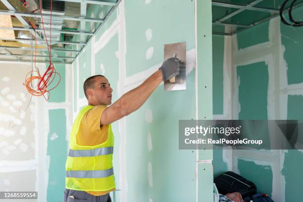 les ouvriers de la construction sont plâtrés un plafond. concept construire une maison - plaquiste photos et images de collection