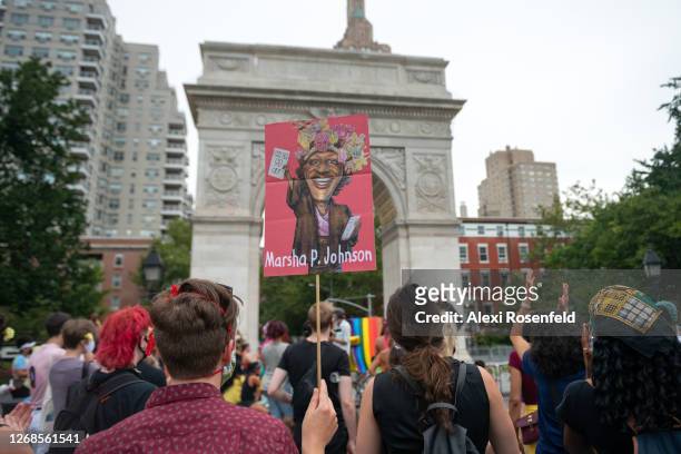 Person holds a "Marsha P. Johnson" sign with the Washington Square Park Arch in the background at the Rally Held On Birthday Of Trans Activist Marsha...